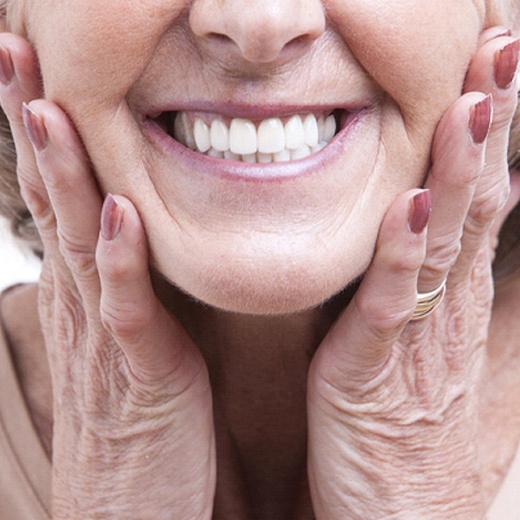 Closeup of smiling woman with implant dentures in Cleveland