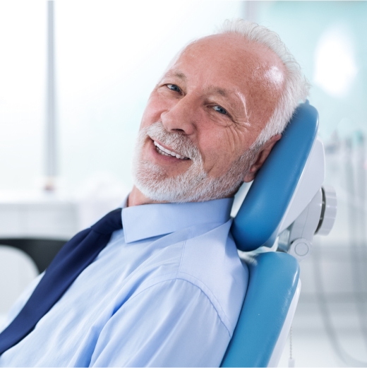 Man with dentures smiling in dental chair