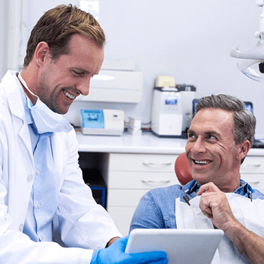 Dentist talking to patient about dentures in Cleveland