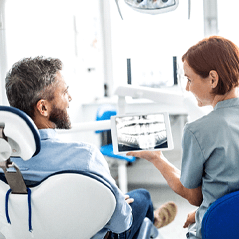 Dentist explaining cost of dentures in Cleveland to patient