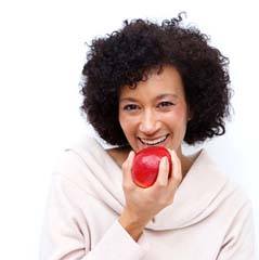 Woman with dental implants in Cleveland eating an apple