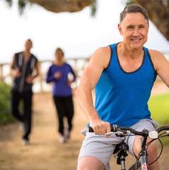 Healthy man with dental implants in Cleveland riding a bike