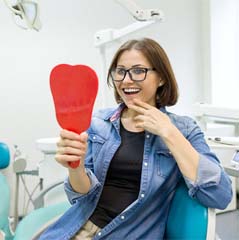 Young woman admiring her new dental implants in Cleveland