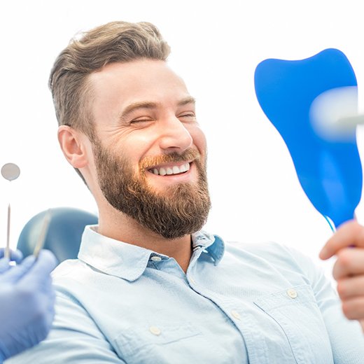 Man smiling after receiving dental implants in Cleveland