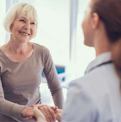 Older woman shaking hands with an implant dentist in Cleveland TX