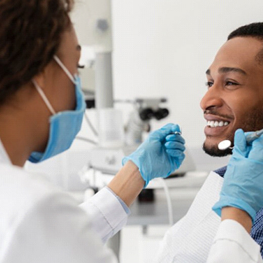 a patient smiling while getting a dental checkup