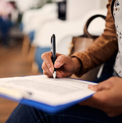 a patient writing on an insurance form