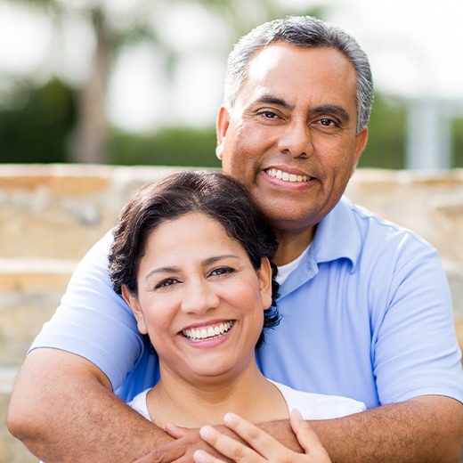 Man and woman smiling after denture repair