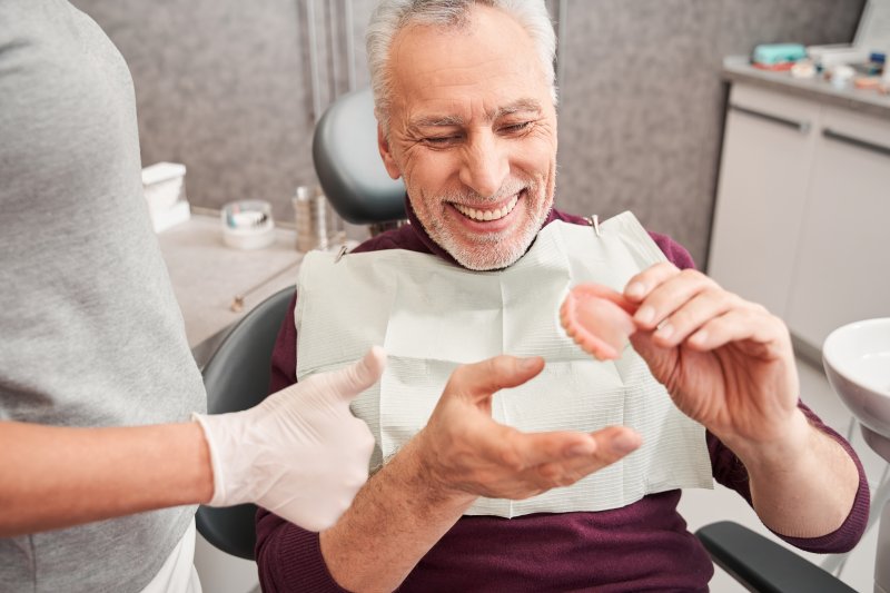 a patient in Cleveland smiling after replacing his dentures